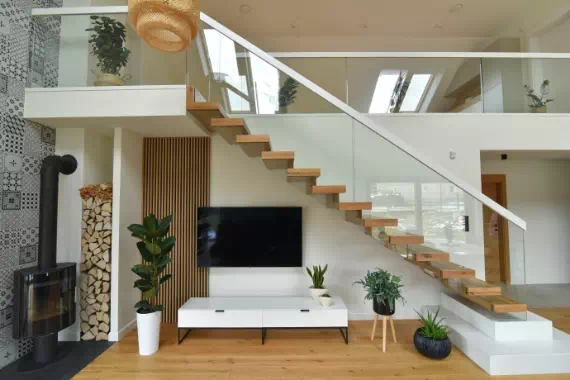 Salon z telewizorem oraz schody prowadzące na piętro